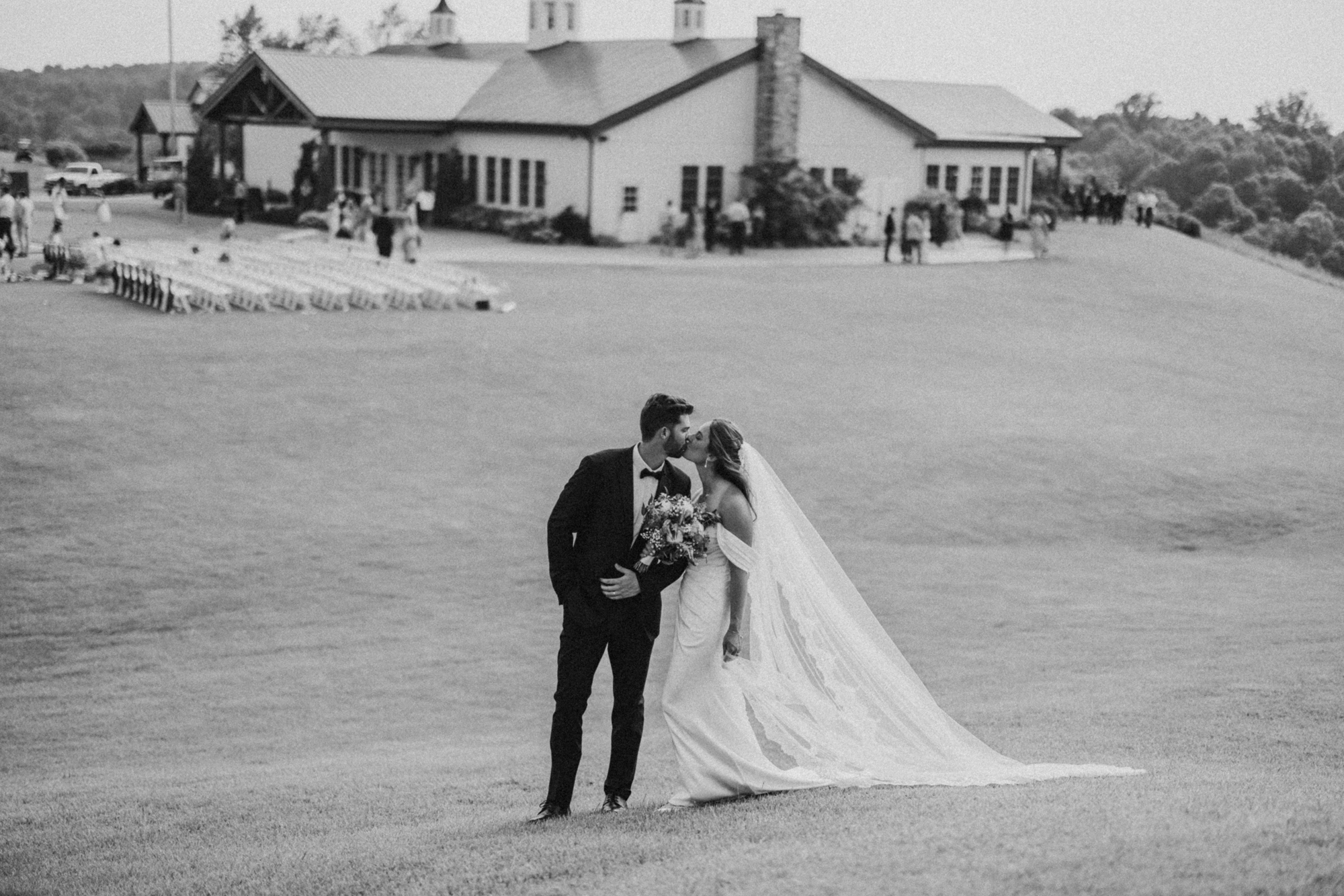 Bride and groom kiss on the hill outside Pete Dye Pavilion at French Lick Resort